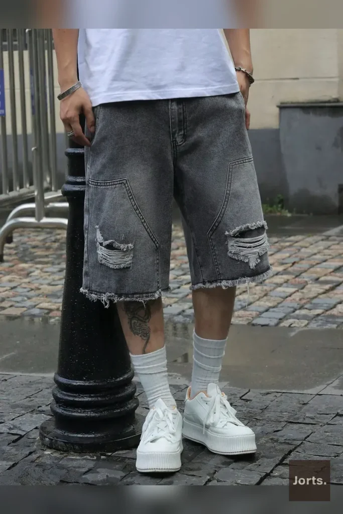 Close-up of the gray cotton denim fabric on men's straight-leg shorts, highlighting texture.